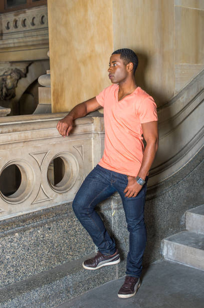 istock Young black college student standing inside office building, looking around. 1335097883