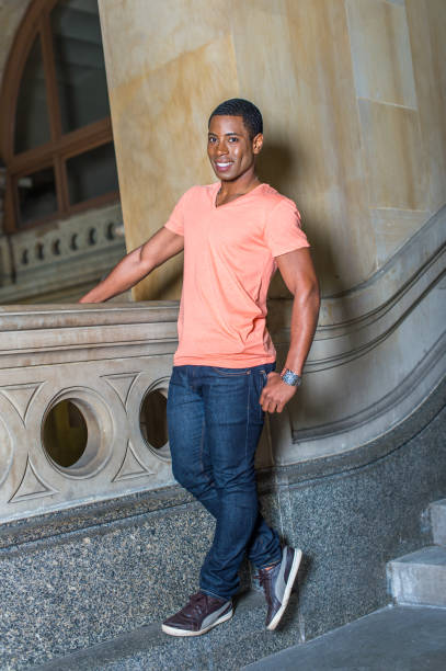 istock Young black college student standing inside office building, looking around. 1335097931