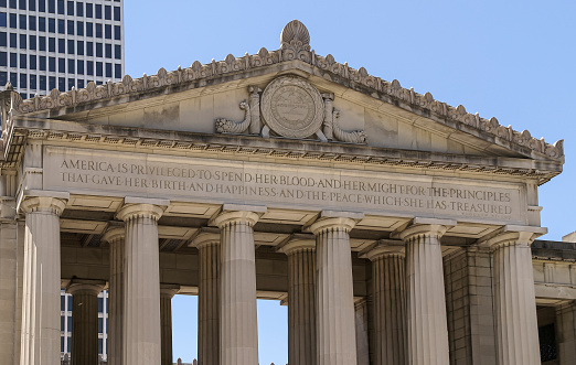 Nashville, TN, USA - June 17, 2007: Downtown. Beige stone War Memorial building in Green-Roman style with pillars under blue sky. Closeup of triangle on top with fresco and text.