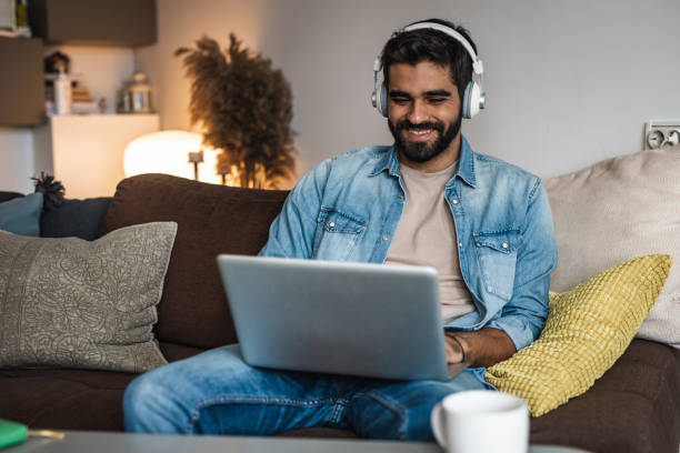 istock Portrait of a young man using laptop at home 1335109248