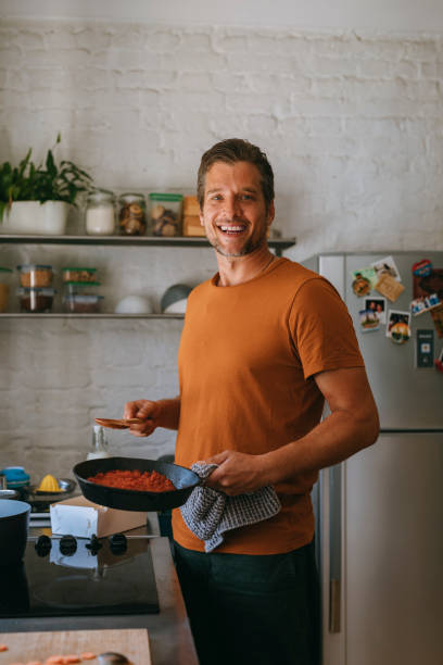 istock Happy Handsome Caucasian Man Holding a Pan While Making a Meal at Home 1335109296
