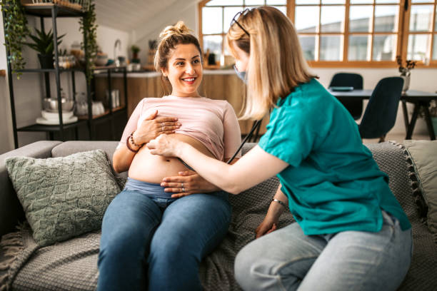 istock Home caregiver examining pregnant woman using stethoscope 1335113072