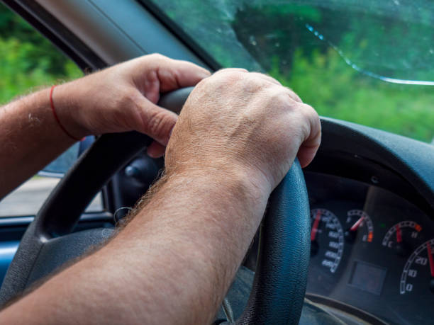 istock Men's hands on the steering wheel. 1335114469