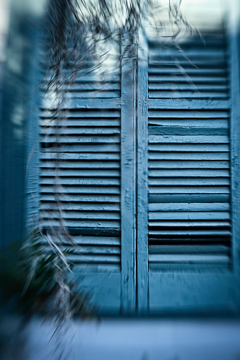 Distorted view of worn green shutters on the porch of Myrtles Plantation, St. Francisville; Louisiana; USA;
