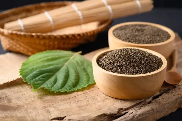 Perilla seeds in a bowl on wooden background, Healthy herbal seed ingredients in Asian food