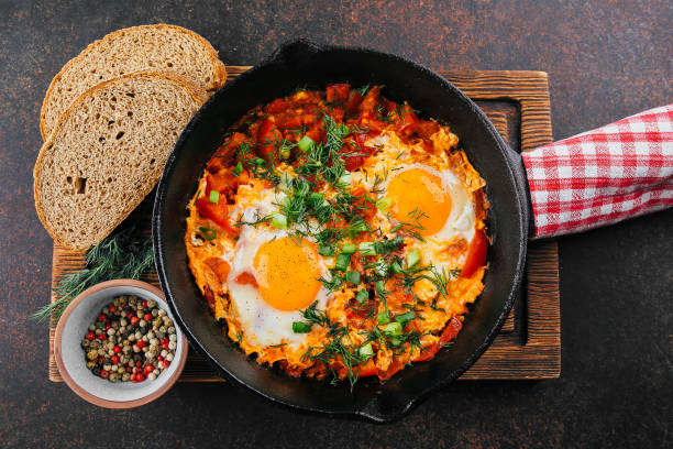 istock Shakshuka in a pan. Middle eastern traditional dish. Fried eggs with tomatoes sause. Top view 1335137710
