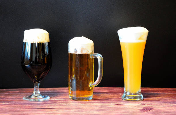 trzy różne szklanki jasnego, ciemnego i pszenicznego piwa znajdują się na drewnianym stole. - draught beer variation three objects zdjęcia i obrazy z banku zdjęć