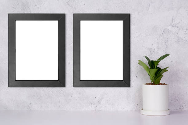 istock Mockup black frame vertical on the wall and plants in pot on table top at home, mock up poster for presentation on desk, your design for gallery photo and picture, border template for advertising. 1335149015