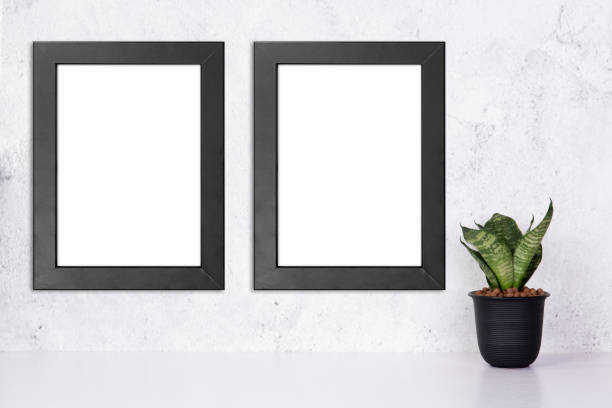 istock Mockup black frame vertical on the wall and plants in pot on table top at home, mock up poster for presentation on desk, your design for gallery photo and picture, border template for advertising. 1335149024