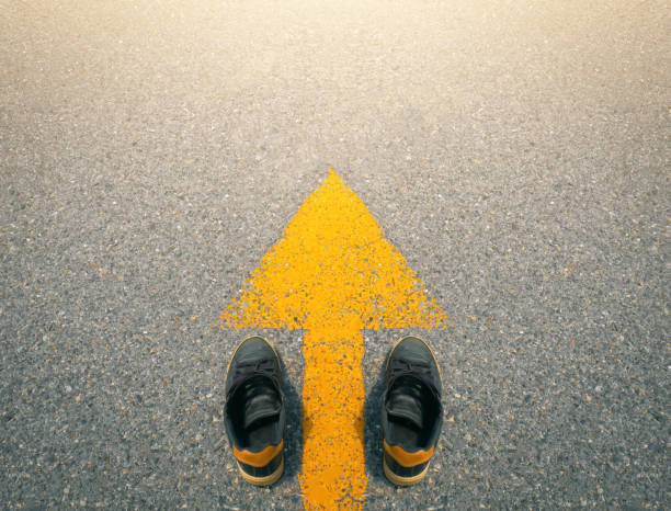 istock Shoe and arrows on road background. 1335152116