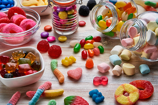 High angle view close-up of an assortment of colorful jellybeans, lollipops, candies and marshmallows.