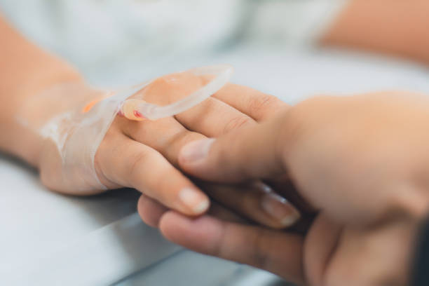 primer plano del marido sosteniendo a los pacientes de la mano en el hospital,pacientes salinos, iv goteo, mano con aguja intravenosa de goteo médico, dar agua salada en el hospital. - infusion needle fotografías e imágenes de stock