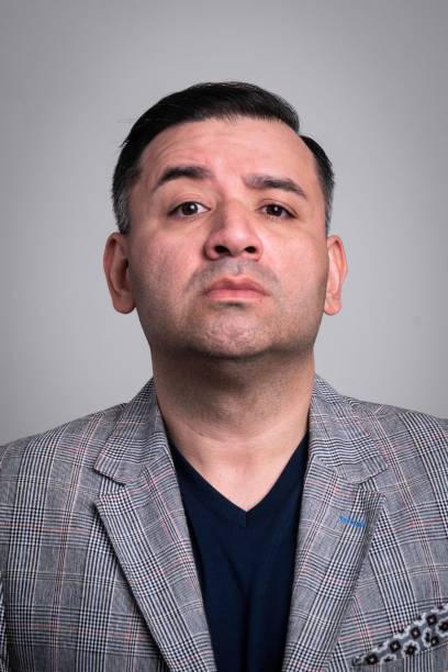 istock Serious mature man looking at the camera on gray background 1335159837