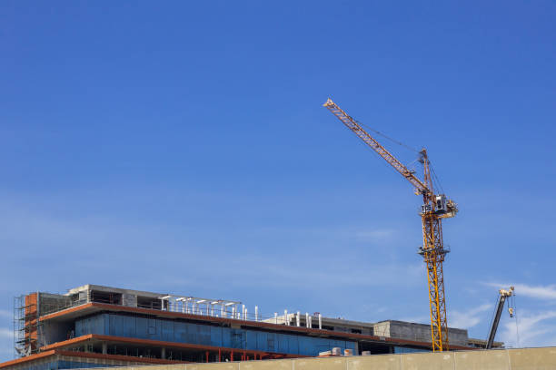 istock Hight rising crane working on construction site build tower with space of blue sky background 1335161578