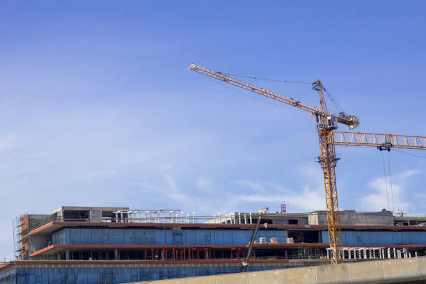 istock Hight rising crane working on construction site build tower with space of blue sky background 1335161579