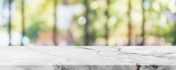 istock Empty white marble stone table top and blur glass window interior restaurant banner mock up abstract background - can used for display or montage your products. 1335162457