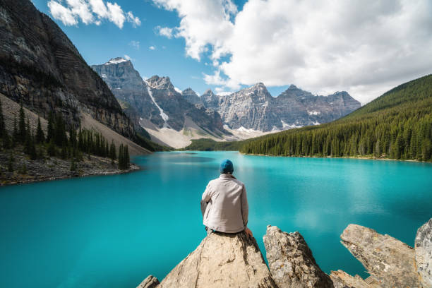 escursionista guardando la vista sul lago moraine, banff national park, alberta, canada - canadian culture landscape mountain range mountain foto e immagini stock
