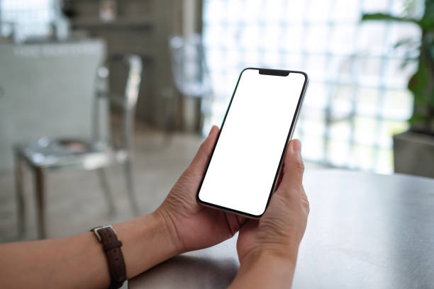 istock a woman holding mobile phone with blank white desktop screen 1335168034