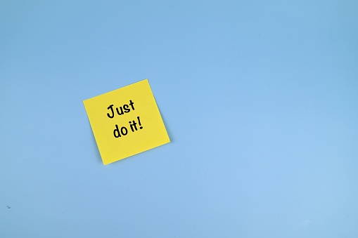 Yellow sticky note with JUST DO IT wording on blue background