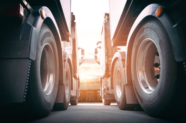 due semi-camion un parcheggio al magazzino con sunset sky. trasporto di camion merci cargo del settore. - truck tire foto e immagini stock