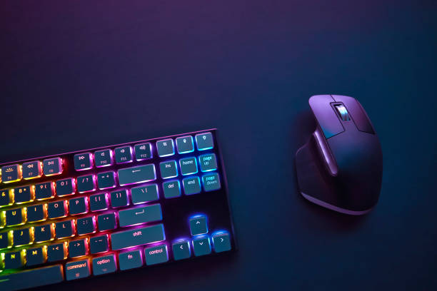 istock Top down view of vivid color backlighted computer keyboard and mouse against dark background. 1335173966