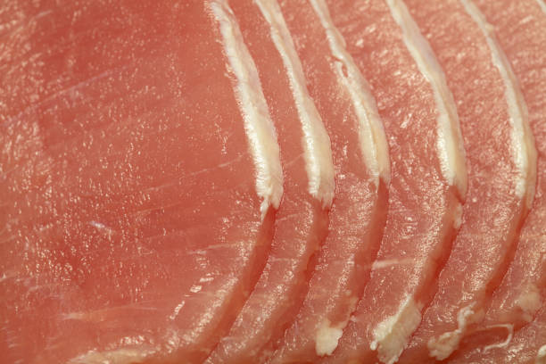 Raw marinated pork lean loin cut into thin sliced with almost all of the fat trimmed