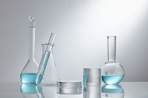 Different glassware with light blue liquid on table in laboratory