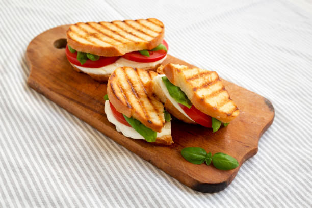 istock Tasty Grilled Caprese Panini (Mozzarella, Tomatoes and Basil) on a rustic wooden board, low angle view. Close-up. 1335176622