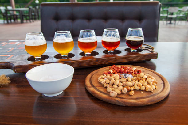 juego de cerveza, juego de vasos de cerveza clara y oscura sobre un fondo de pub. bandeja de muestra de cerveza artesanal - rustic beer brewery indoors fotografías e imágenes de stock