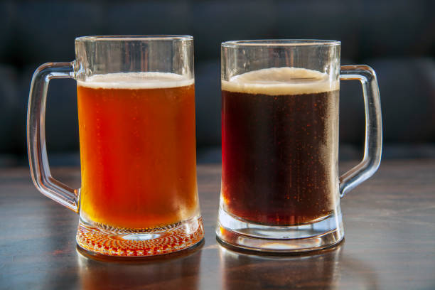 istock two large mugs of dark and light beer 1335178908