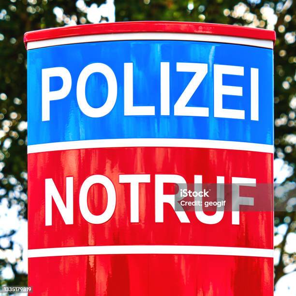 Upper Part Of Red And Blue Colored Emergency Call Pillar With German Inscription Notruf Und Polizei Stock Photo - Download Image Now