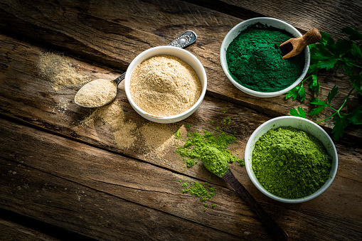 Nutritional supplements: Spirulina, Maca and Moringa powder in white bowls shot from above on rustic wooden table. High resolution 42Mp studio digital capture taken with Sony A7rII and Sony FE 90mm f2.8 macro G OSS lens