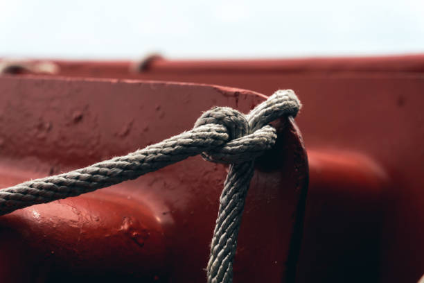 Knot rope tied around stake on boat.