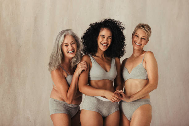 les femmes embrassant ensemble leur corps matural - bady care photos et images de collection