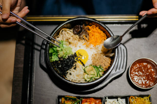 istock Woman eating bibimbap in Korean restaurant 1335187964