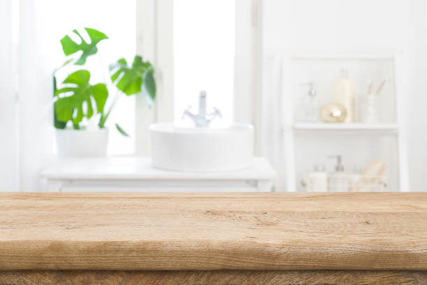 istock Empty wooden table top with blurred bathroom sink interior background 1335189638