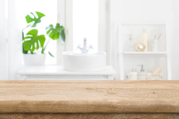 Empty wooden table top with blurred bathroom sink interior background stock photo