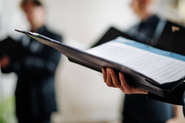 istock Hand holds notes during choir rehearsal and scrolls, shallow depth of field 1335191435