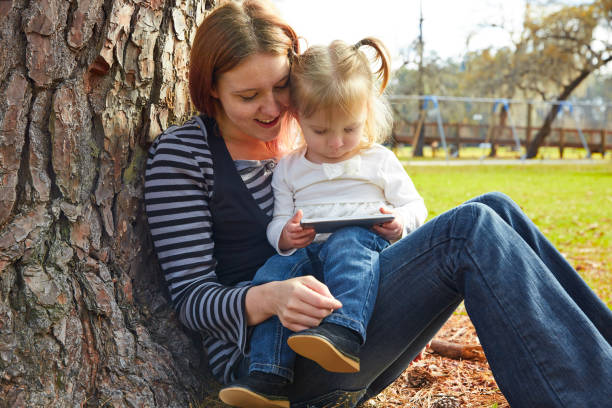 istock mother and daughter playing with smartphone 1335193411