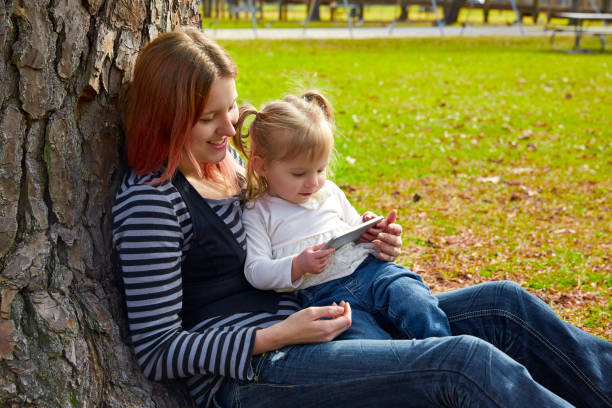 istock mother and daughter playing with smartphone 1335194071