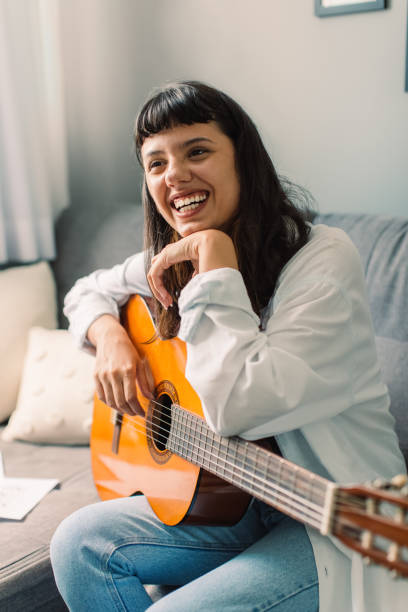 istock Smiling female musician holding a guitar 1335194749
