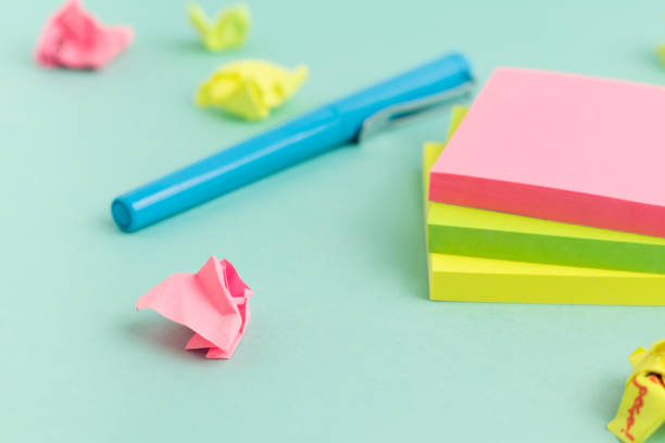istock Crumpled papers, pen and empty colorful sticky note paper on turquoise background. Selective Focus. 1335195752