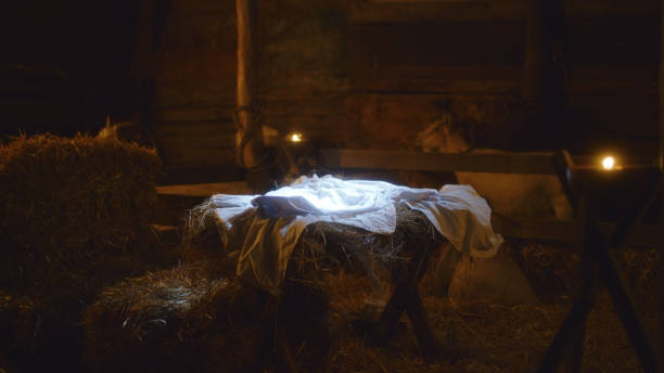 Manger for son of God in stable White sheet placed in illuminated manger prepared for baby Jesus Christ in dark inn barn in Bethlehem country inn stock pictures, royalty-free photos & images