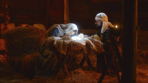 istock Mary and Joseph caressing baby Jesus in illuminated manger 1335199358