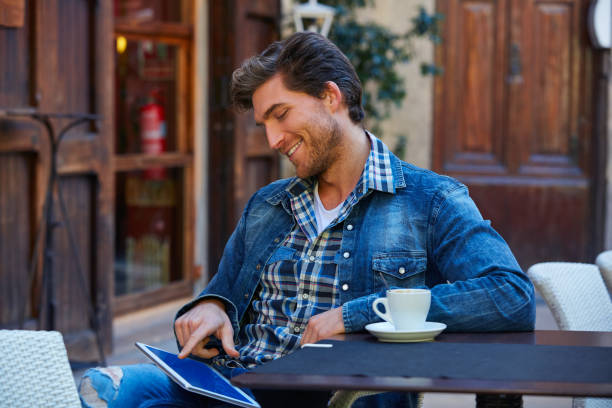 istock Young man with tablet pc touch in an cafe 1335203655
