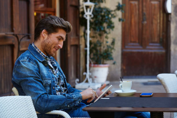 istock Young man with tablet pc touch in an cafe 1335203806