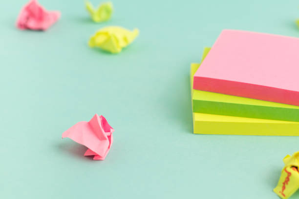 istock Crumpled papers and empty colorful sticky note paper on turquoise background. Selective Focus. 1335204712