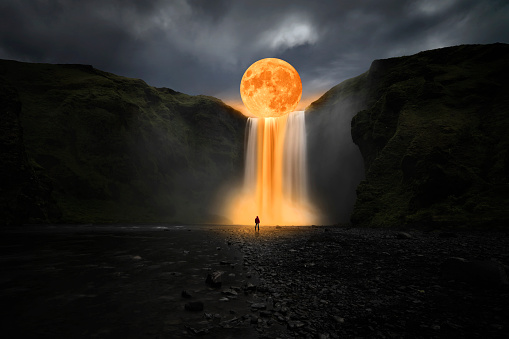 Luna naranja sobre gran cascada photo