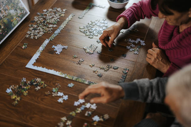 Senior couple having fun while doing a jigsaw puzzle at home