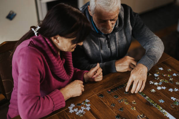 istock Concentrated senior couple doing a jigsaw puzzle at home 1335205299